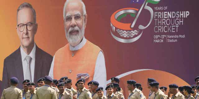 Indian policemen stand in front of a hoarding featuring Australian Prime Minister Anthony Albanese and Indian Prime Minister Narendra Modi in Ahmedabad, India, on March 7, 2023. Albanese plans to visit president Joe Biden in the United States after his trip to India.