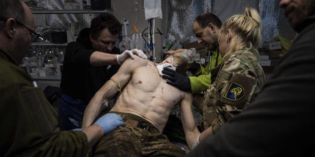 Ukrainian military medics treat their wounded comrade at a field hospital near Bakhmut, Ukraine, Feb. 26, 2023.