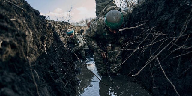 Ukrainian soldiers shelter in a trench during Russian shelling near Bakhmut, Ukraine, March 5, 2023.