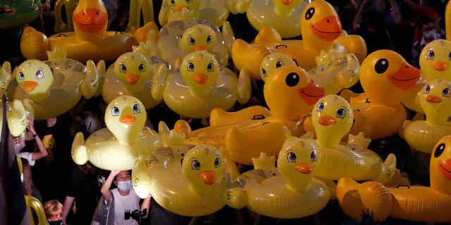 Inflatable yellow ducks, which have become symbols of resistance during anti-government rallies, are lifted over a crowd of protesters in Bangkok, Thailand, on Nov. 27, 2020. A Thai man was sentenced to two years in prison on March 7, 2023, for selling calendars featuring satirical cartoons that a court said mocked the country’s monarch.