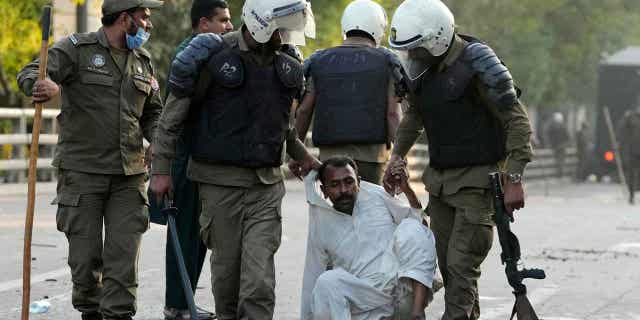 Police officers detain a supporter of Pakistan's former Prime Minister Imran Khan during a clash in Lahore, Pakistan, on March 8, 2023.