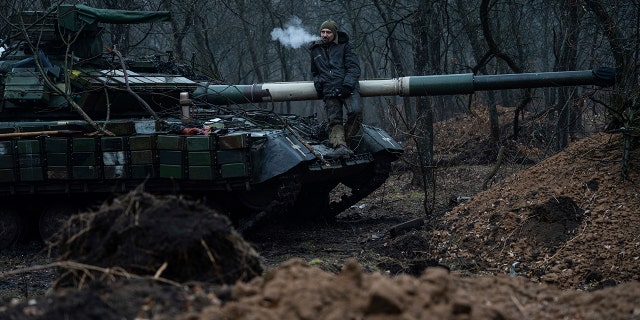 A Ukrainian serviceman smokes a cigaret standing atop on the tank near Bakhmut, Ukraine, Wednesday, March 8, 2023. 