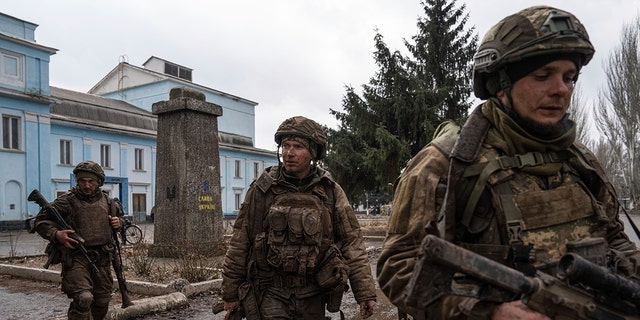 Ukrainian servicemen walk on a street as they just come back from tranches of Bakhmut in Chasiv Yar, Ukraine, Wednesday, March 8, 2023. 