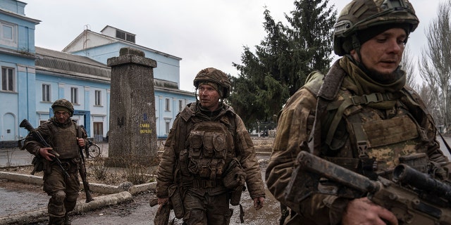 Ukrainian servicemen walk down the street as he returns from Bakhmut's tranches in Chasiv Yar, Ukraine on Wednesday, March 8, 2023. 