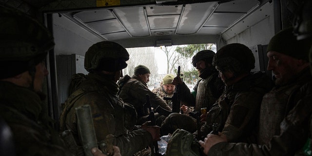 Ukrainian servicemen sit inside a van in Chasiv Yar, Ukraine on Wednesday, March 8, 2023. 
