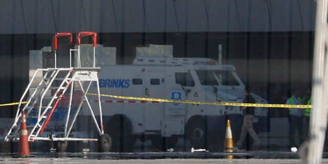 An armored truck is surrounded by police tape at the Arturo Merino Benitez International Airport in Santiago, Chile, Wednesday, March, 8, 2023. An airport shootout killed a security officer and an alleged robber, authorities say.