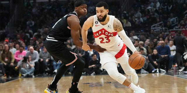 El número 23 de los Raptors de Toronto, Fred VanVleet, pasa junto al número 14 de los Clippers de Los Ángeles, Terance Mann, durante la primera mitad de un partido de baloncesto de la NBA el miércoles 8 de marzo de 2023 en Los Ángeles. 