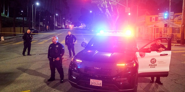 Police officers stand guard near the crime scene where three LAPD officers were shot and killed on Wednesday, March 8, 2023 in Los Angeles. 