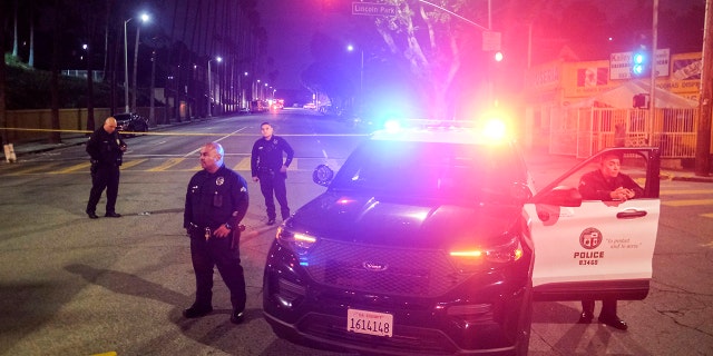 Police officers stand guard near a crime scene where three Los Angeles police officers were shot, Wednesday, March 8, 2023, in Los Angeles. 