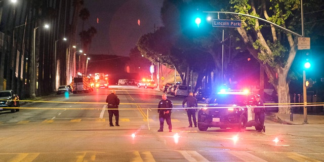 Police officers stand guard near the crime scene where three LAPD officers were shot and killed on Wednesday, March 8, 2023 in Los Angeles. 
