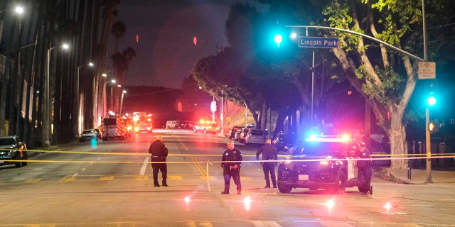 Police officers stand guard near a crime scene where three Los Angeles police officers were shot, Wednesday, March 8, 2023, in Los Angeles. 