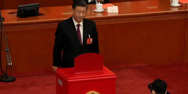 Chinese President Xi Jinping looks up after casting his vote to select state leaders during a session of China's National People's Congress (NPC) at the Great Hall of the People in Beijing, Friday, March 10, 2023. 