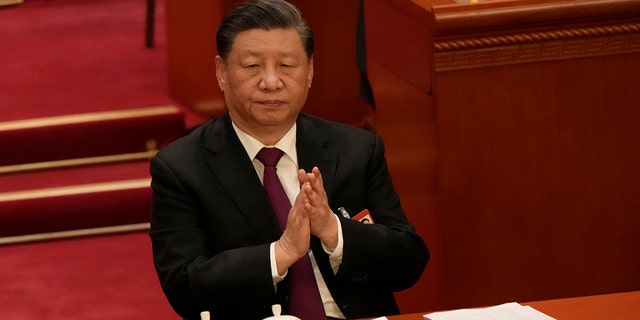 Chinese President Xi Jinping applauds during a session of the Chinese National People's Congress (NPC) at the Great Hall of the People in Beijing on Friday, March 10, 2023. 