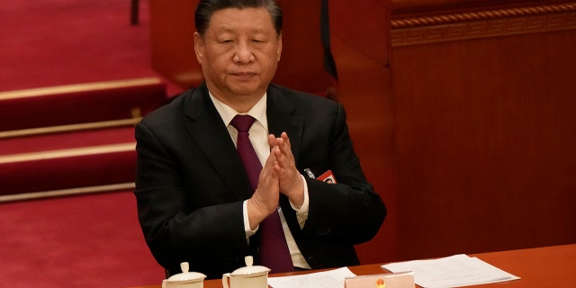 Chinese President Xi Jinping applauds during a session of the Chinese National People's Congress (NPC) at the Great Hall of the People in Beijing on Friday, March 10, 2023. 