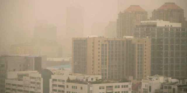 Haze and dust envelops buildings in Beijing on March 10, 2023. Air quality in the capital city plummeted because of dust storms and air pollution.