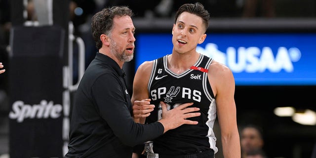 San Antonio Spurs' Zach Collins, right, is held by Spurs assistant coach Matt Nielsen after an on-court altercation in the second half of an NBA basketball game against the Denver Nuggets, on Friday, March 10, 2023, in San Antonio. 