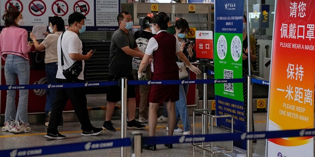 An airliner worker asks the traveler to declare their health information after checking in at the international flight check-in counter at Beijing Capital International Airport in Beijing, Aug. 24, 2022. 