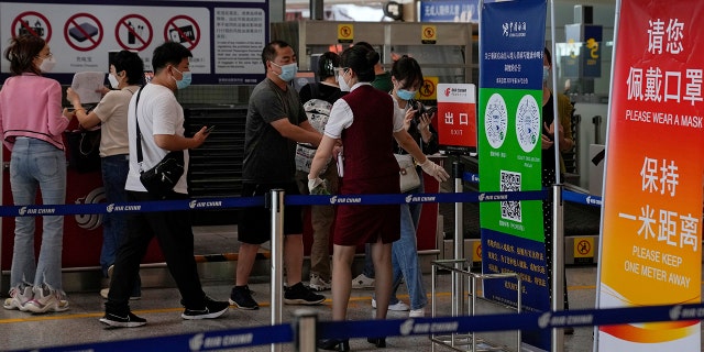 An airliner worker asks the traveler to declare their health information after checking in at the international flight check-in counter at Beijing Capital International Airport in Beijing, Aug. 24, 2022. 