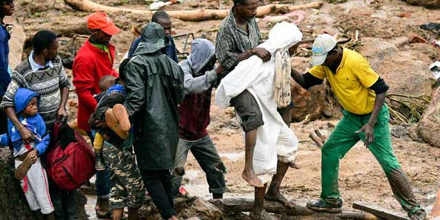 An injured man is pictured being helped in Blantyre, Malawi, on March 13, 2023. Cyclone Freddy is currently battering southern Africa and has killed over 50 people in Malawi and Mozambique since it struck the continent on Saturday night.