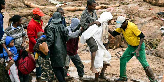 An injured man is pictured being helped in Blantyre, Malawi, on March 13, 2023. Cyclone Freddy is currently battering southern Africa and has killed over 50 people in Malawi and Mozambique since it struck the continent on Saturday night.