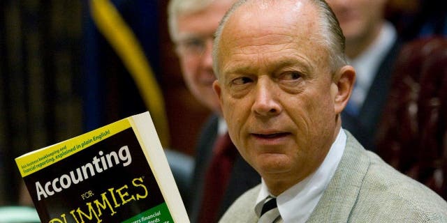 South Carolina Comptroller General Richard Eckstrom holds up a book he wanted to present to his new Chief of Staff James Holly during his introduction at the Budget and Control Board meeting, Aug. 13, 2009, in Columbia, S.C.