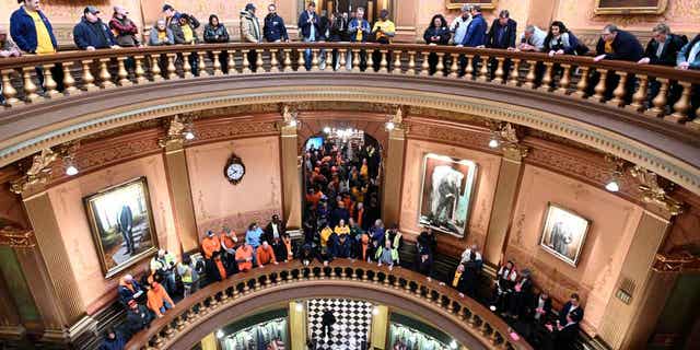 Union members and supporters chant in Michigan's Capitol rotunda on March 14, 2023, as they wait for a "right-to-work" bill to be voted on. Michigan Senate Democrats voted to repeal the "right-to-work" law in the state.    