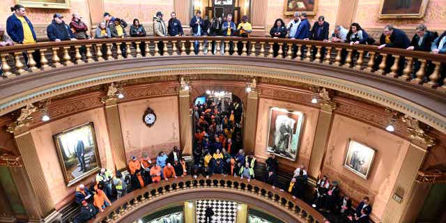 Union members and supporters chant in Michigan's Capitol rotunda on March 14, 2023, as they wait for a "right-to-work" bill to be voted on. Michigan Senate Democrats voted to repeal the "right-to-work" law in the state.