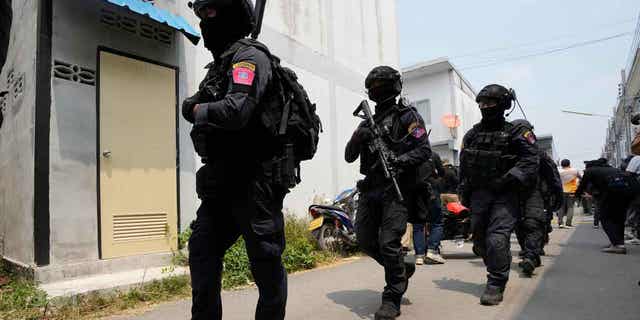 A group of police officers leave the home of a senior police officer in Bangkok, Thailand, on March 15, 2023. Thai police have arrested the officer after he fired multiple gunshots from his home. Due to the incident, Thai officers will be subjected to random physical and mental health evaluations.