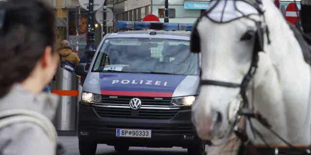 A police van drives past horses at a cathedral in Vienna, Austria, on Mar 15, 2023. Austrian police are warning of a possible "Islamist-motivated attack" targeting churches in Vienna.