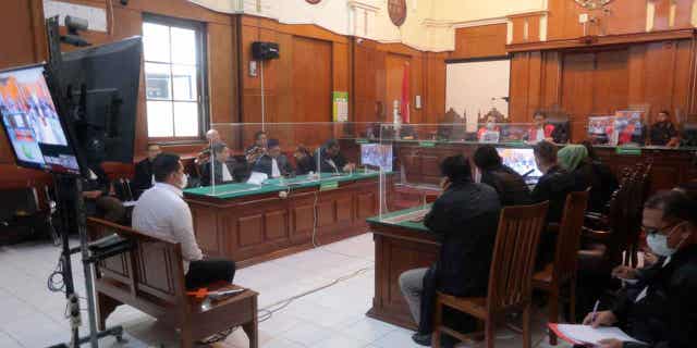 Indonesian court acquits 2 police officials charged with negligence in connection to fatal stadium disaster 2 Police officer Hasdarmawan, left, sits on the defendant's chair during his sentencing hearing at a district court in Surabaya, Indonesia, on March 16, 2023. The Indonesian court sentenced Hasdarmawan to 18 months in prison for negligence leading to the deaths of 135 people in October. Other officers who played less of a role in the incident were acquitted in court.