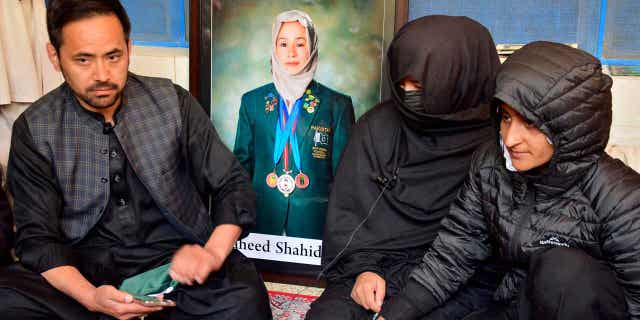 Sister Sadia Raza, center, relative Naimatullah Hazara, left, and friend Sumiaya Kianat, right, of Pakistani field hockey player Shahida Raza, who died in the shipwreck tragedy, attend her funeral, in Quetta, Pakistan, on March 17, 2023. 