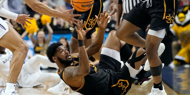 Kennesaw State's Demond Robinson, bottom, battles for a loose ball during the first half of a first-round game against Xavier in the NCAA Tournament Friday, March 17, 2023, in Greensboro, N.C.