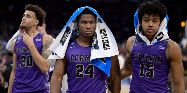 Furman forward Jalen Slawson (20), forward Alex Williams (24) and forward Tyrese Hughey (15) leave the court after their loss to San Diego State in a second round college basketball game in the College Basketball Tournament. NCAA, on Saturday, March 18, 2023, in Orlando, Florida. 