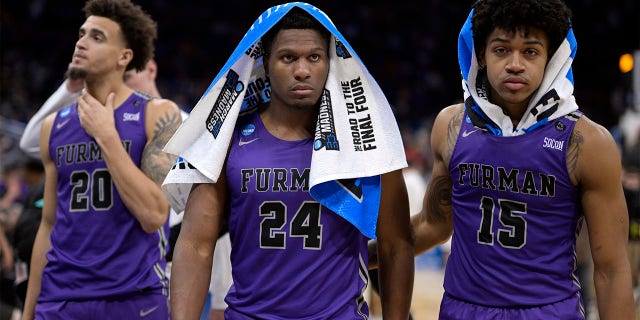 Furman forward Jalen Slawson (20), forward Alex Williams (24) and forward Tyrese Hughey (15) leave the court after their loss to San Diego State in a second-round college basketball game in the NCAA Tournament, Saturday, March 18, 2023, in Orlando, Fla.