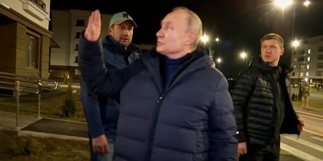 Russian President Vladimir Putin greets local residents after touring their new apartment during his visit to Mariupol in the Russian-controlled Donetsk region of Ukraine.