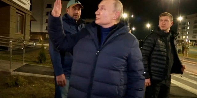 Russian President Vladimir Putin greets local residents after touring their new apartment during his visit to Mariupol in the Russian-controlled Donetsk region of Ukraine.