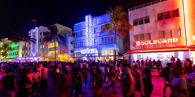 Crowds walk up and down Ocean Drive during spring break on Saturday, March 18, 2023, in Miami Beach, Fla. Miami Beach officials imposed a curfew beginning Sunday night, March 19, after two fatal shootings and rowdy, chaotic crowds that police have had difficulty controlling. 