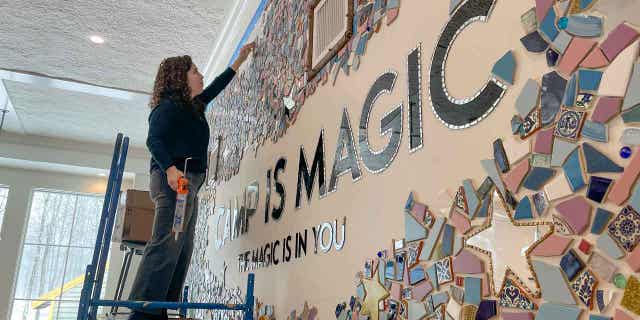 Artist Mia Schon finishes a mural in one of the activity rooms of the Hole In the Wall Gang Camp on March 2, 2023, in Ashford, Connecticut. Two years after a fire destroyed Paul Newman's camp for seriously ill children, the rebuilt camp center is opening.