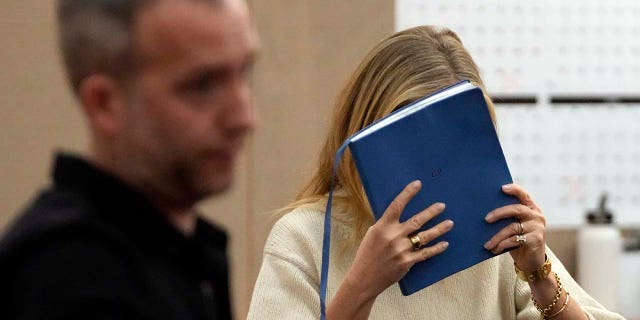 Gwyneth Paltrow shields her face with a blue notebook as she exits a courtroom Tuesday, March 21, 2023, in Park City, Utah. 