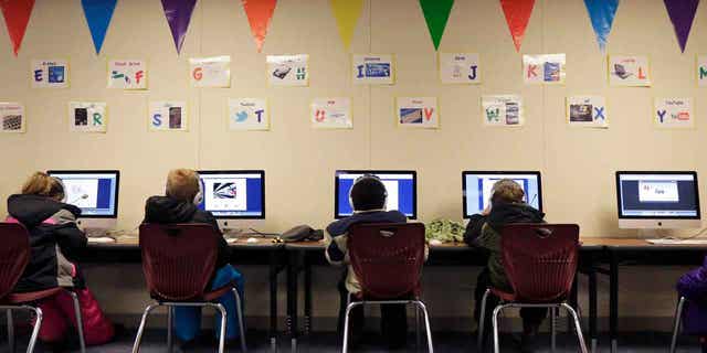 Watford City Elementary School students use computers in Watford City, North Dakota, on Dec. 17, 2014. The state House passed a bill on March 22, 2023, that would prohibit schools from requiring teachers to call students by the pronouns they use, if those pronouns differ from what was assigned at birth. 