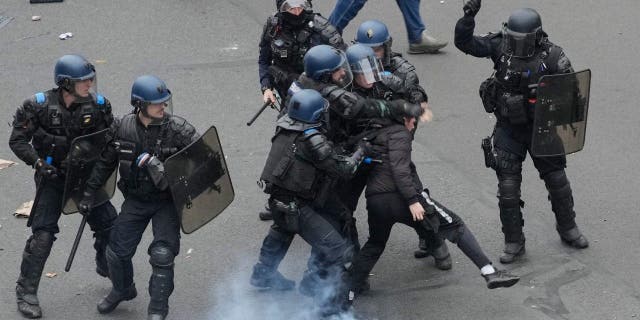 Macron se enfrenta a una protesta de 800.000 personas en París por la reforma de las pensiones 4 La policía antidisturbios choca con un manifestante durante una manifestación en París, el jueves 23 de marzo de 2023. Los sindicatos franceses realizan sus primeras manifestaciones masivas desde que el presidente Emmanuel Macron avivó la ira pública al imponer una edad de jubilación más alta en el parlamento sin votación.