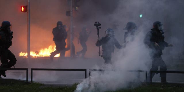 Riot polices scuffle with protesters on the sideline of a rally in Strasbourg, eastern France, Thursday, march 23, 2023. French unions are holding their first mass demonstrations Thursday since President Emmanuel Macron enflamed public anger by forcing a higher retirement age through parliament without a vote.