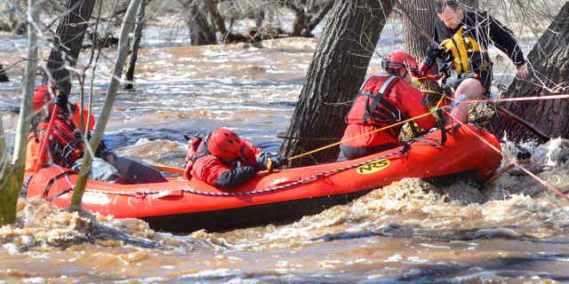 A man stuck in a tree is rescued by a team from Copper Canyon Fire and Medical District on March 22, 2023, in Camp Verde, Arizona. Several water rescues were reported across central and northern Arizona on Wednesday. Three people have been killed so far in the flooding.