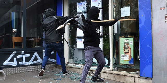 Las protestas en Francia contra las reformas de pensiones de Macron se intensifican cuando la policía usa 4.000 bombas de dispersión no letales 5 Los manifestantes rompen un escaparate durante una manifestación contra el plan del gobierno de elevar la edad de jubilación a 64 años, en París el 15 de marzo de 2023.