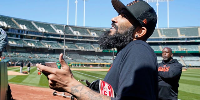 San Francisco Giants pitcher Sergio Romo visits with fans before the start of a spring training baseball game against the Oakland Athletics in Oakland, Calif., on Sunday, March 26, 2023. The Giants plan that Romo pitches Monday at Oracle Park to mark his retirement. 