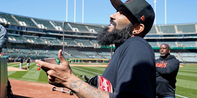 San Francisco Giants pitcher Sergio Romo visits with fans before the start of a spring training baseball game against the Oakland Athletics in Oakland, Calif., on Sunday, March 26, 2023. The Giants plan that Romo pitches Monday at Oracle Park to mark his retirement. 