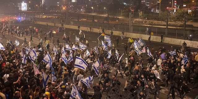 Israeli police disperse demonstrators blocking a highway during a protest against Prime Minister Benjamin Netanyahu's government plans to overhaul the judicial system in Tel Aviv, Israel, on Monday, March 27, 2023. 
