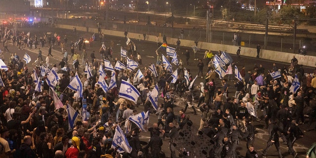 Israeli police disperse demonstrators blocking a highway during a protest against plans by Prime Minister Benjamin Netanyahu's government to overhaul the judicial system in Tel Aviv, Israel, Monday, March 27, 2023. 