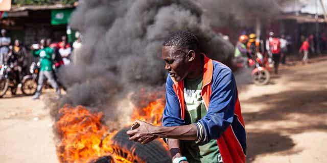 Protestas antigubernamentales han estallado en Kenia a pesar de que el gobierno declaró ilegales las protestas. 4 Un manifestante reacciona junto a una barricada en llamas durante una manifestación convocada por Raila Odinga por el alto costo de la vida en Nairobi, el 27 de marzo de 2023. La policía de Kenia se prepara para la segunda ronda de protestas antigubernamentales organizadas por la oposición. El gobierno lo calificó de ilegal.