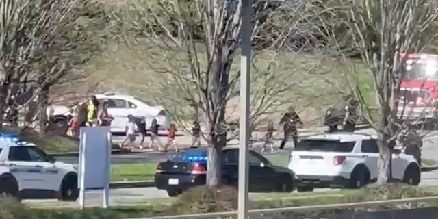 Law enforcement officers lead children away from the scene of a shooting at The Covenant School, a private Christian school in Nashville, Tenn., on Monday March 27, 2023. (Jozen Reodica via AP)